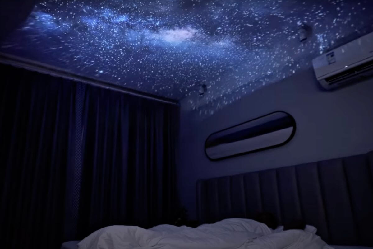 ETOE Starfish Plus Projektor im Test mit eingeschaltetem Nachtlicht und projeziert einen Sternenhimmelan die Decke mit einem Objektiv.